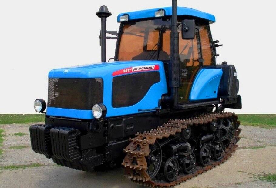 Гусеничный трактор: маленький на гусеницах с ковшом, минитрактор российского производства, техника на ходу для сельского хозяйства, коммунальный земляк